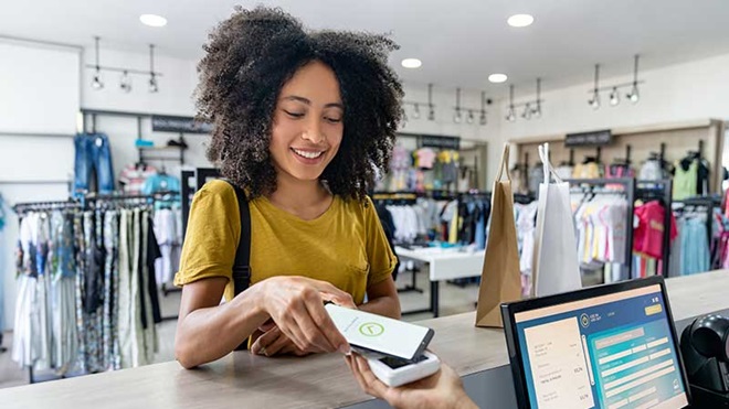 Rapariga a pagar as compras com o telemóvel