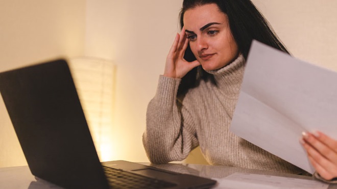 mulher preocupada em frente ao portátil