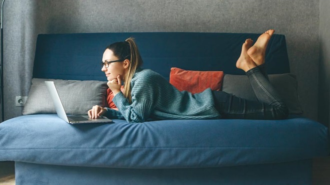 mulher no sofá com o portátil