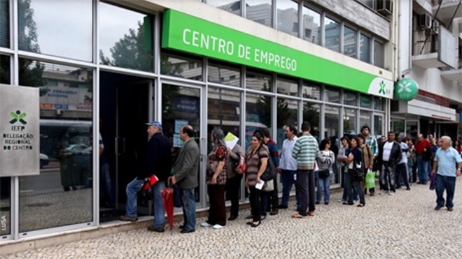 Fila de pessoas à porta de centro de emprego para receber fundo de desemprego