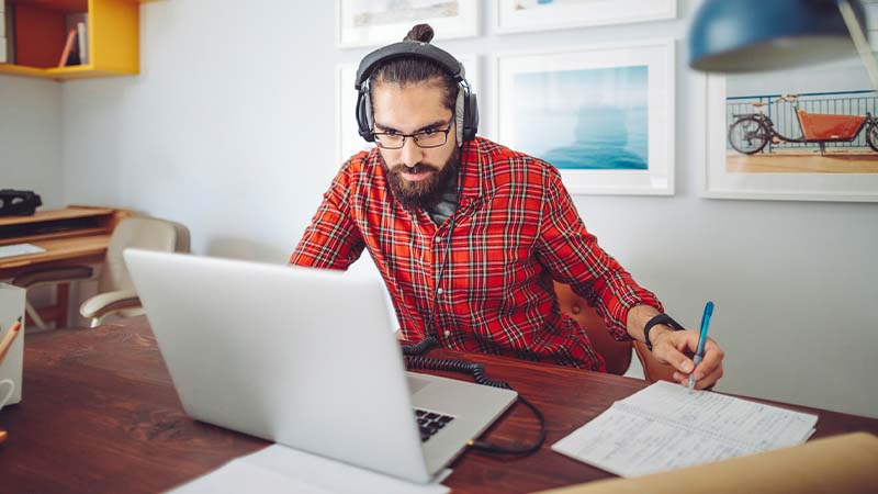 Homem a trabalhar a partir de casa com computador portátil