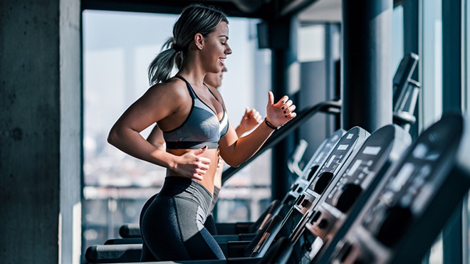 Mulher a correr numa passadeira num ginásio