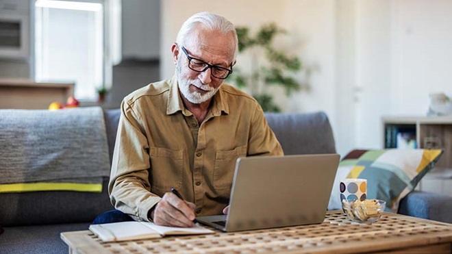 dinheiro empilhado com casas miniatura por cima