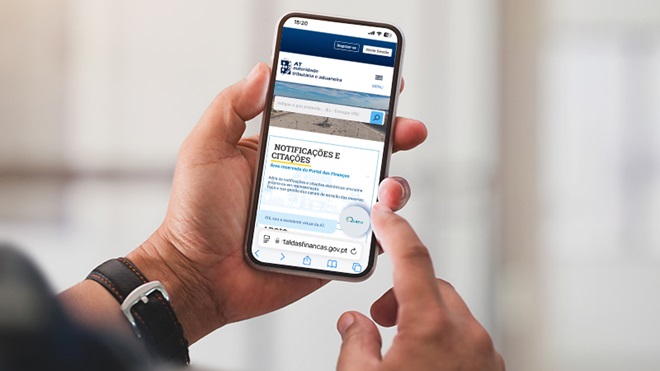 Homem com o Portal das Finanças aberto no telemóvel