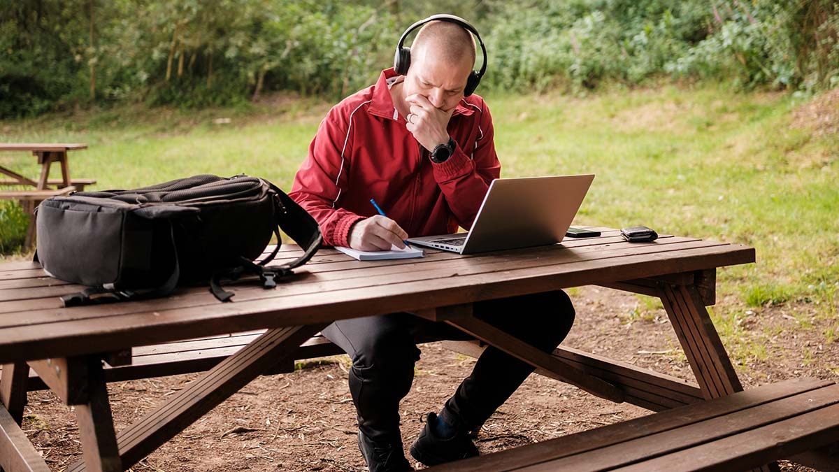 Homem a trabalhar com computador no parque