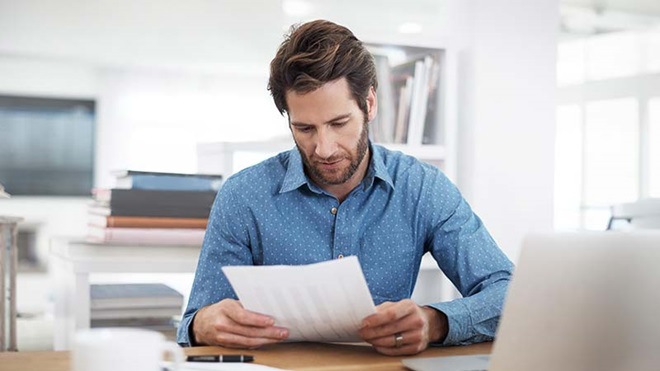 pessoa a utilizar calculadora para confirmar contas da nota de liquidação do IRS