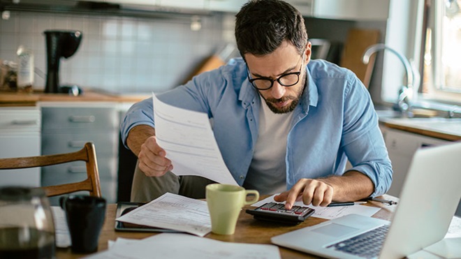 homem a tratar do pagamento de impostos em frente a um computador