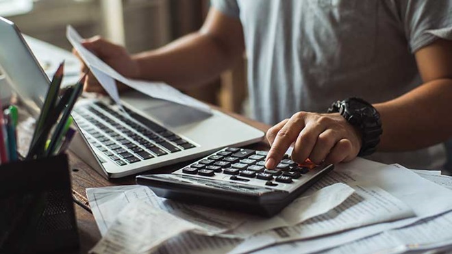 Homem com calculadora e faturas