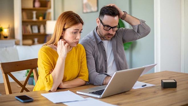 Casal a consultar informação em computador portátil