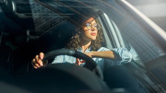 Mulher ao volante de um automóvel, simbolizando os condutores que têm de pagar o IUC em 2025
