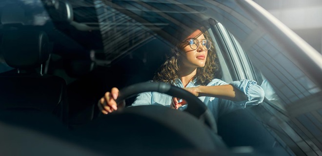Mulher ao volante de um automóvel, simbolizando os condutores que têm de pagar o IUC em 2025