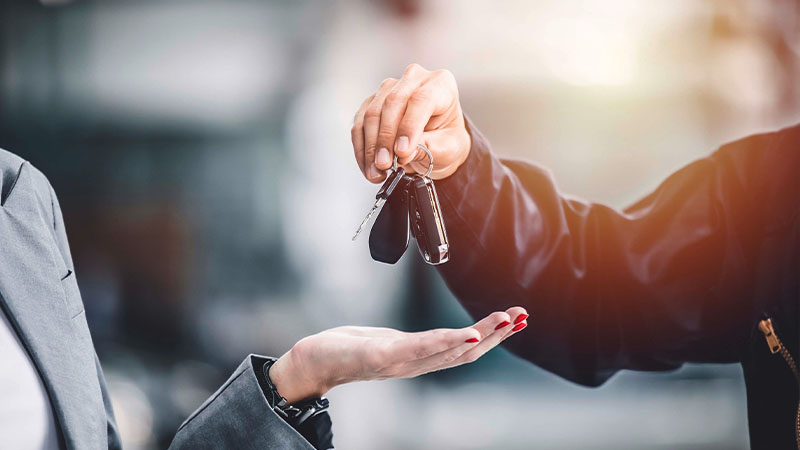 Homem a passar chave de carro a mulher