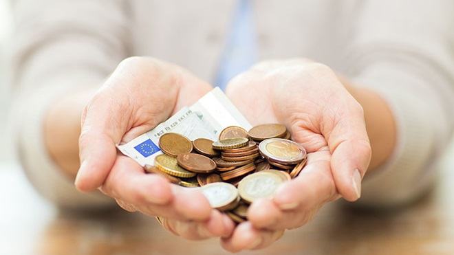 Mão de homem segura várias notas de 100 euros