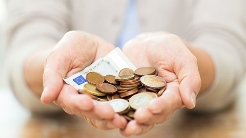 Mão de homem segura várias notas de 100 euros