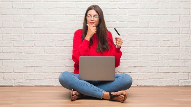 mulher sentada a fazer uma compra online no portátil