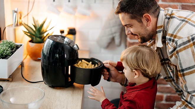 Pai e filho a tirarem as batatas da air fryer