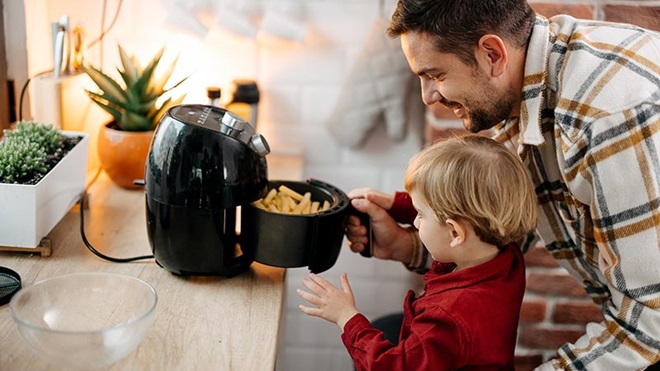 Pai a filho a tirarem batatas da air fryer