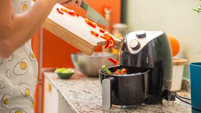 Mulher a cozinhar na air fryer