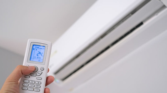 pessoa a ligar aparelho de ar condicionado