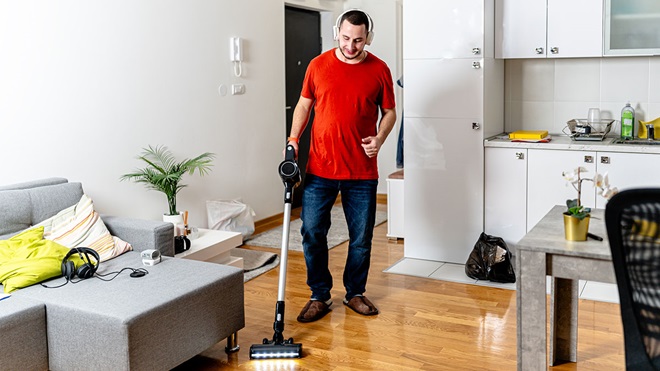 Homem a utilizar aspirador vertical