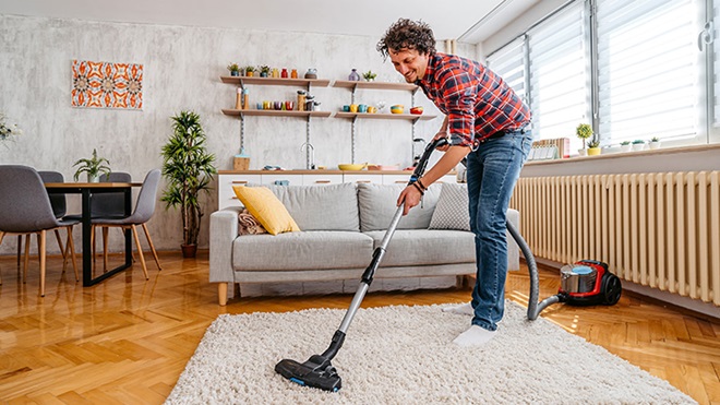 Homem a aspirar tapete