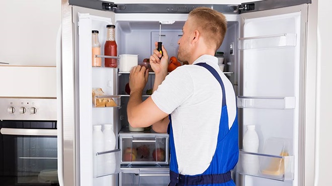 pessoa a reparar um frigorífico