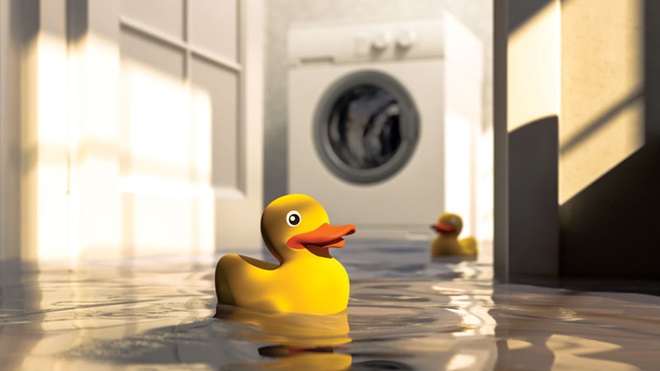Dois patos de borracha de banho numa cozinha inundada por fuga na máquina de lavar roupa