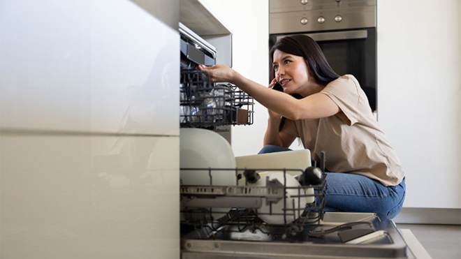 jovem adulta a fazer a manutenção da máquina da loiça 