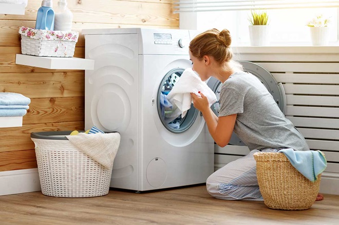 Mulher a tirar a roupa da máquina