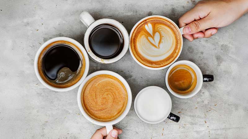 Várias chávenas com café em cima de uma mesa