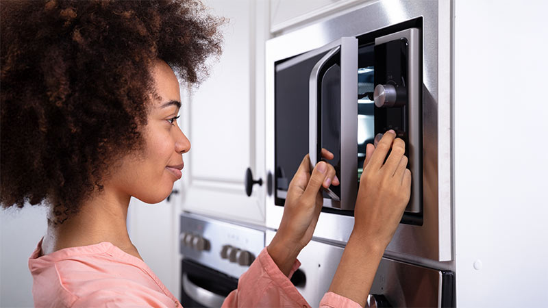 Rapariga a ligar microondas