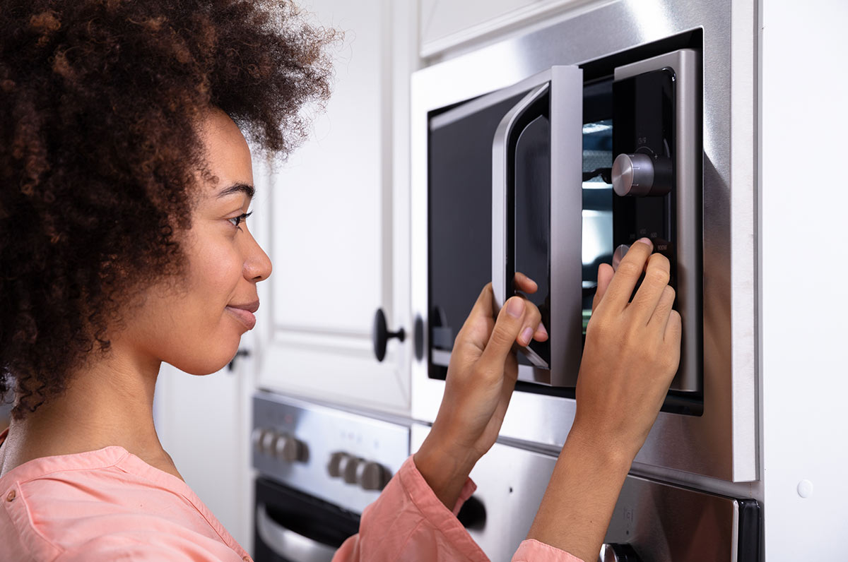 Rapariga a ligar microondas