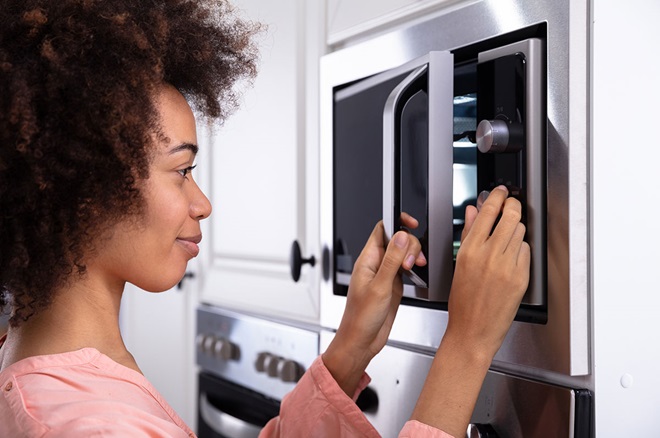 Rapariga a ligar microondas