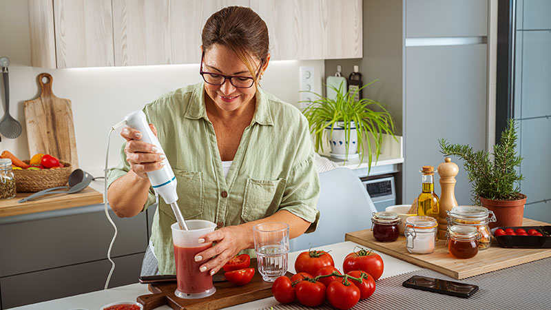 Mulher a triturar tomate com varinha mágica