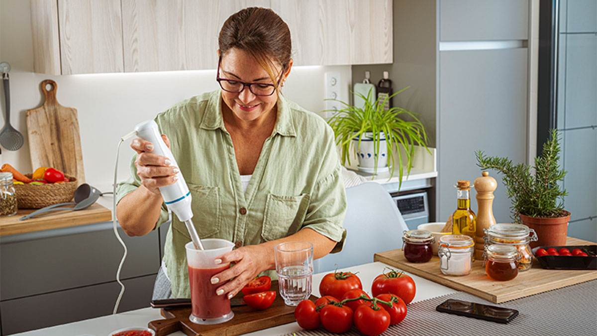 Mulher a triturar tomate com varinha mágica