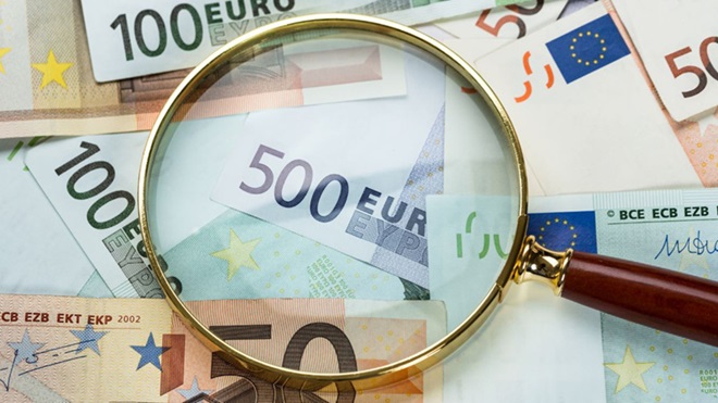 lupa em cima de notas de 500, 100 e 50 euros