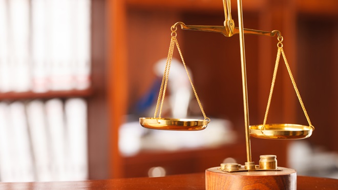 pequena balança dourada, a simbolizar a justiça e o apoio judiciário dado pela Segurança Social