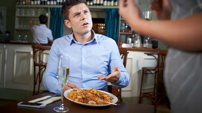 Homem num restaurante a reclamar da comida