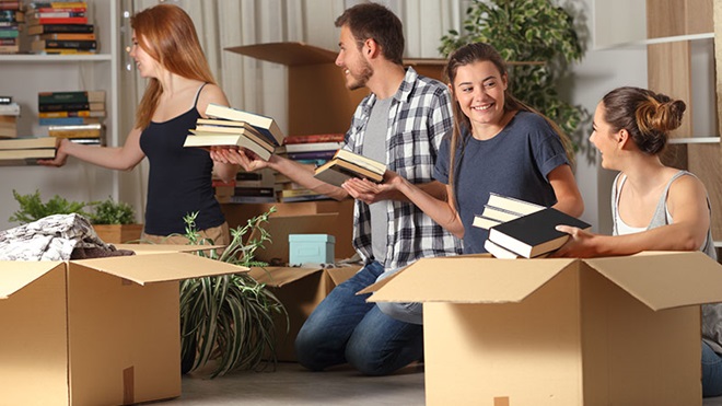estudantes à procura de alojamento arrumam livros na sala