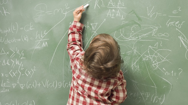 Criança a escrever no quadro com a mão esquerda