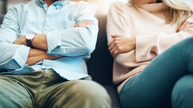 Casal sentado de braços cruzados