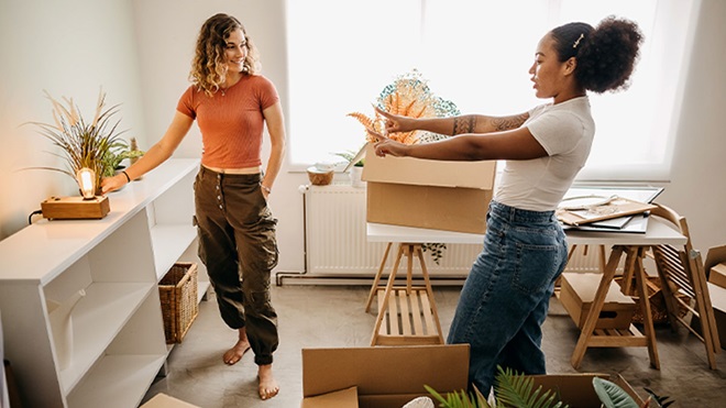 Duas mulheres jovens a arrumar casa nova
