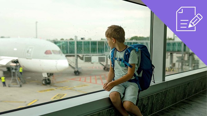 Rapaz menor de idade sentado num terminal de aeroporto com uma mochila às costas, sozinho, a olhar para um avião