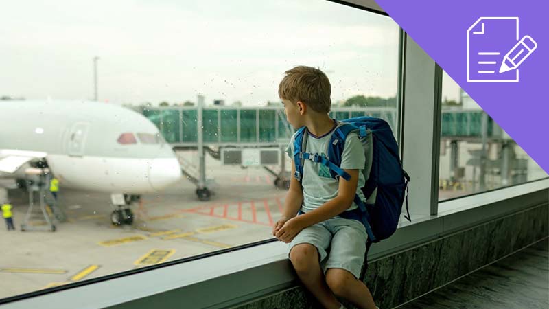 Rapaz menor de idade sentado num terminal de aeroporto com uma mochila às costas, sozinho, a olhar para um avião