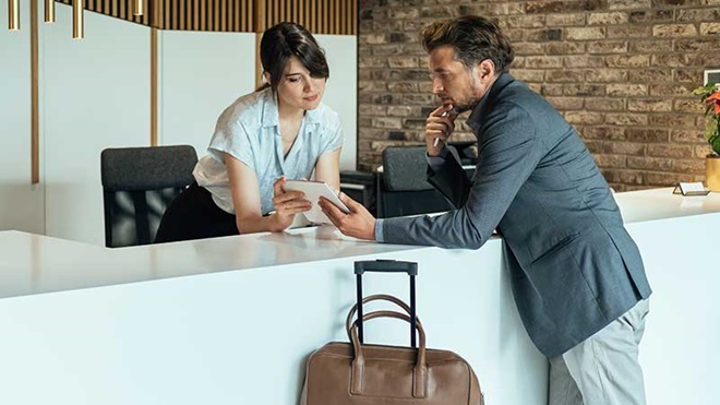 Homem com mala de viagem a entrar em hotel