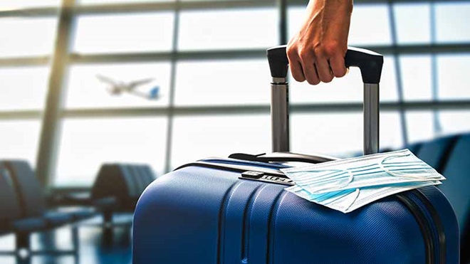 pessoa no aeroporto a puxar uma mala de viagem