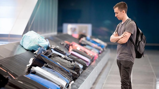 Jovem à espera da mala no aeroporto
