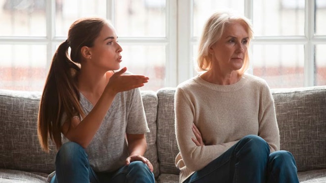 Mãe e filha sentadas no sofá a terem um deentendimento familiar