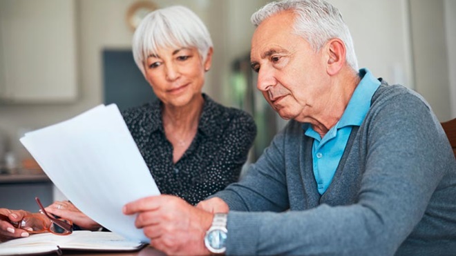 Casal sério sentado diante de um documento importante