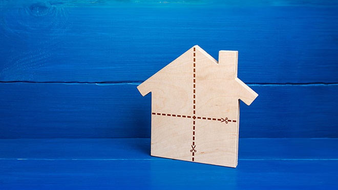 maquete de casa em madeira, plana, dividida em quatro, com um fundo azul atrás